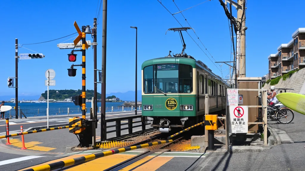 江ノ電鎌倉高校前駅の踏切と江ノ電の列車